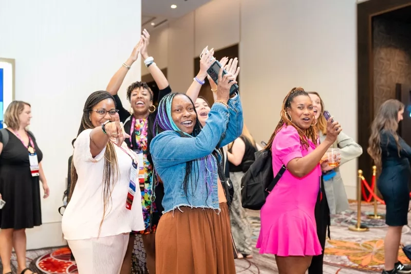 A group of women at Younger Generation Events having fun and dancing with each other.