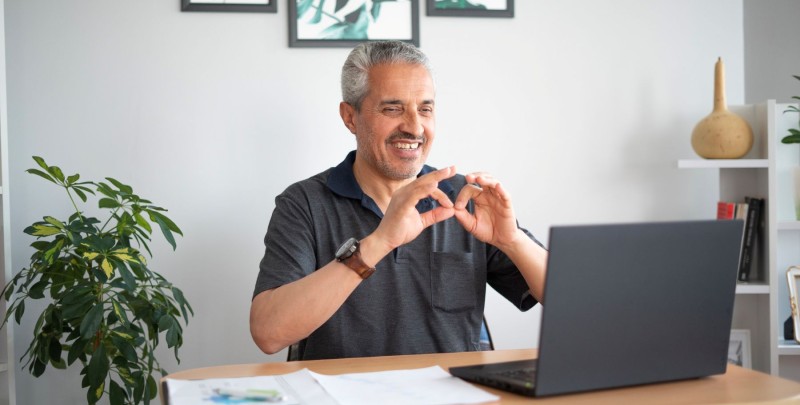 man signing in front of a laptop