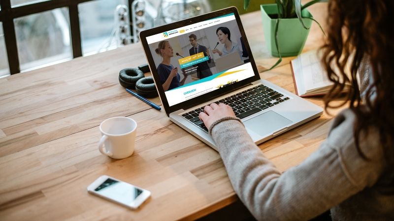 woman typing on laptop with coffee