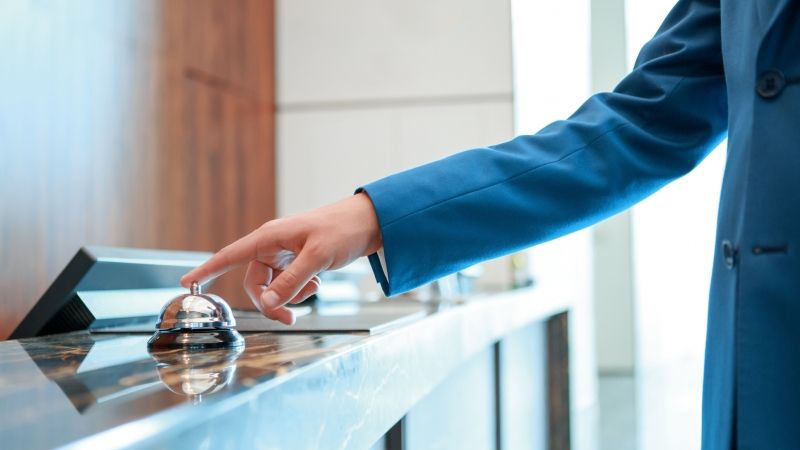 person ringing bell at hotel front desk