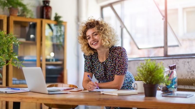 young event planner smiling with laptop