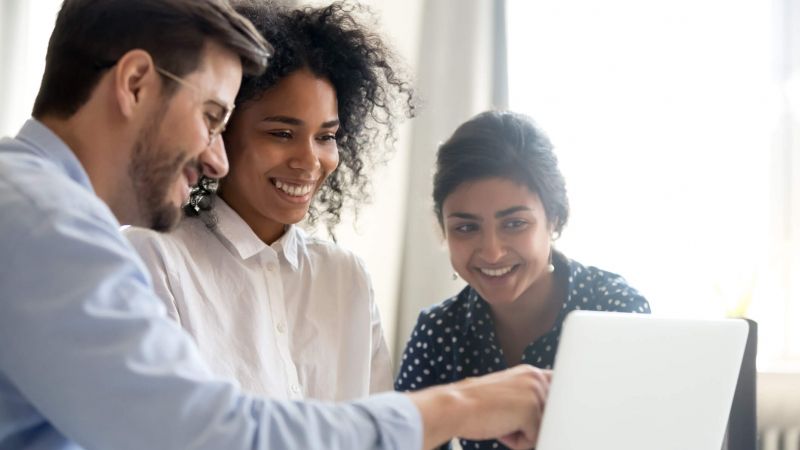 three people looking at laptop presentation during sales management training