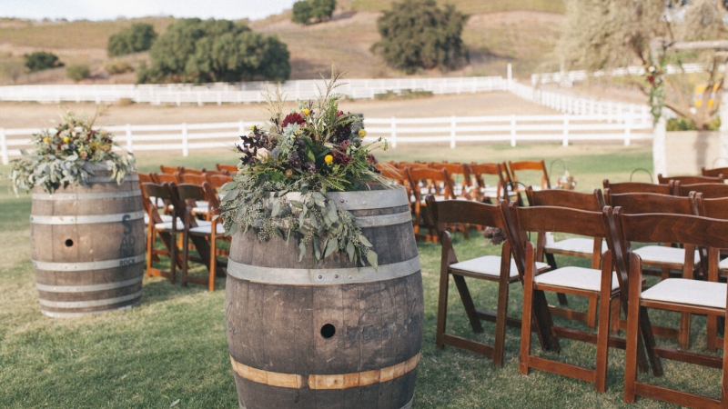 outdoor wedding venue with wood barrels and chairs