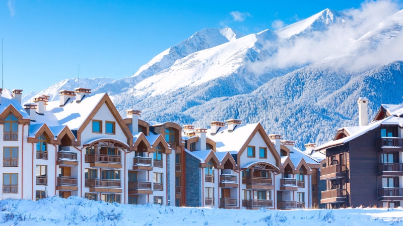 beautiful ski resort with lodging and snow-covered mountains in background