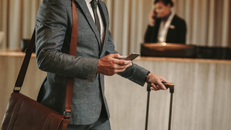 man using hotel mobile check-in on phone in lobby