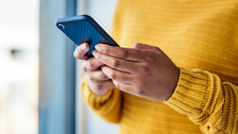 woman holding phone scrolling through social media