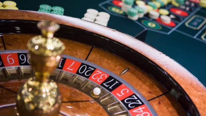 casino table with roulette wheel and chips