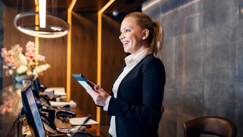 women greets guests in the hotel lobby