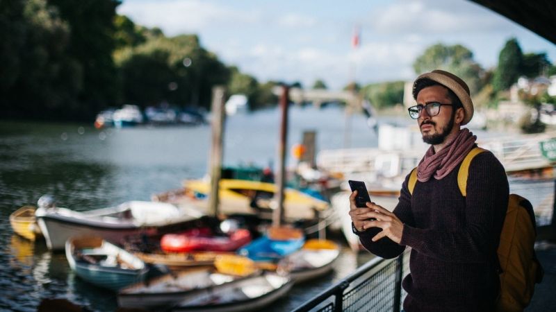 Destination marketing professional taking photo with cell phone near river